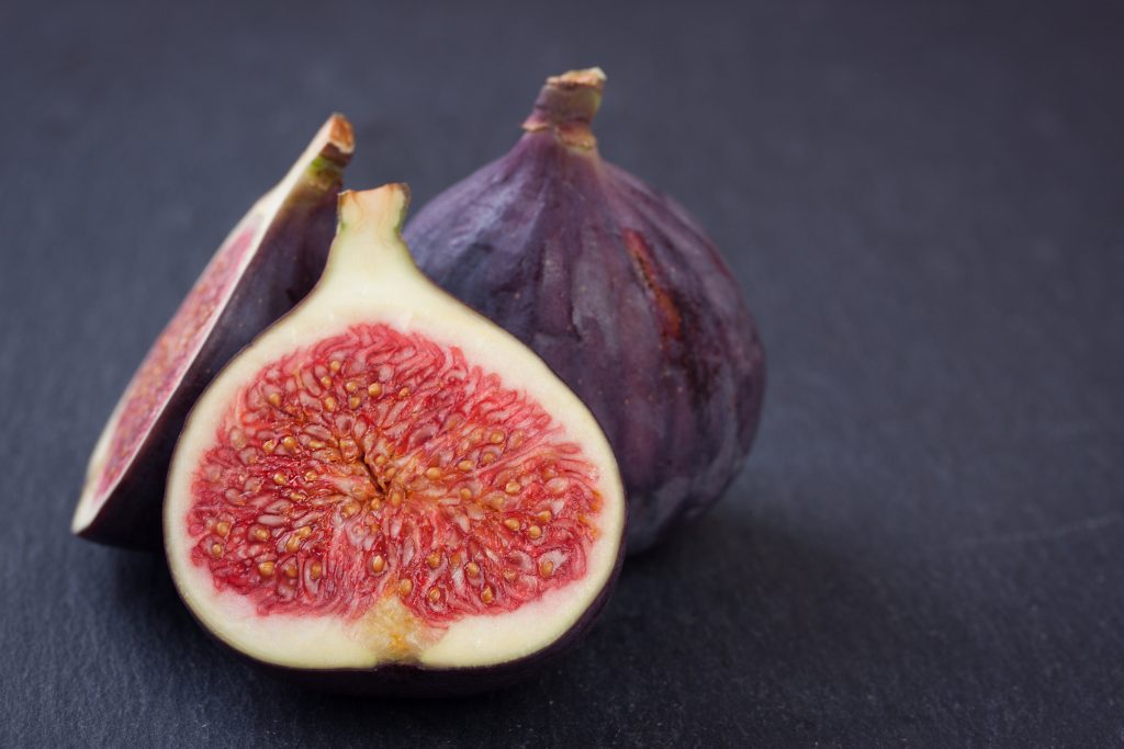 Fresh figs on black stone background